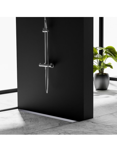 Esempio di doccia aperta su pavimento grigio cemento in effetto marmo con scarico a muro e accessori color argento